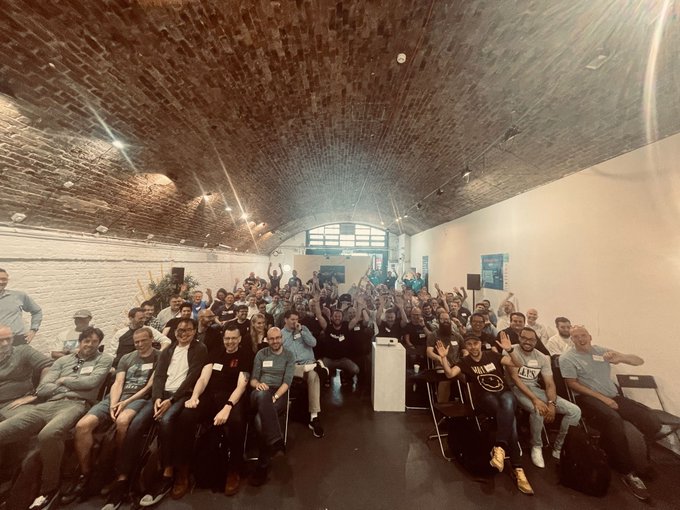NetDevOps Days London attendees smile for the camera at the end of the event.